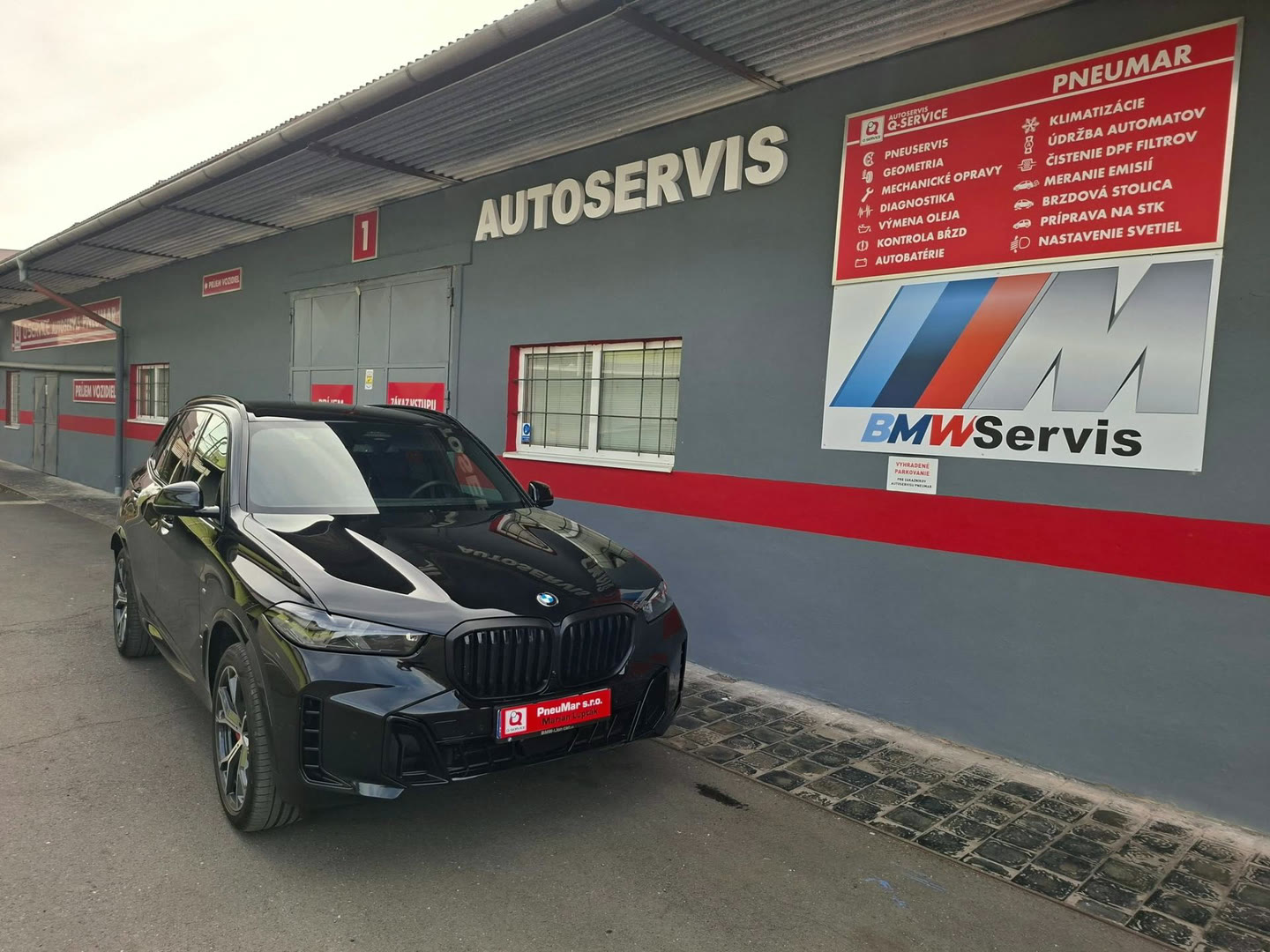 Budova autoservisu PneuMar v Lučenci s vozidlom BMW